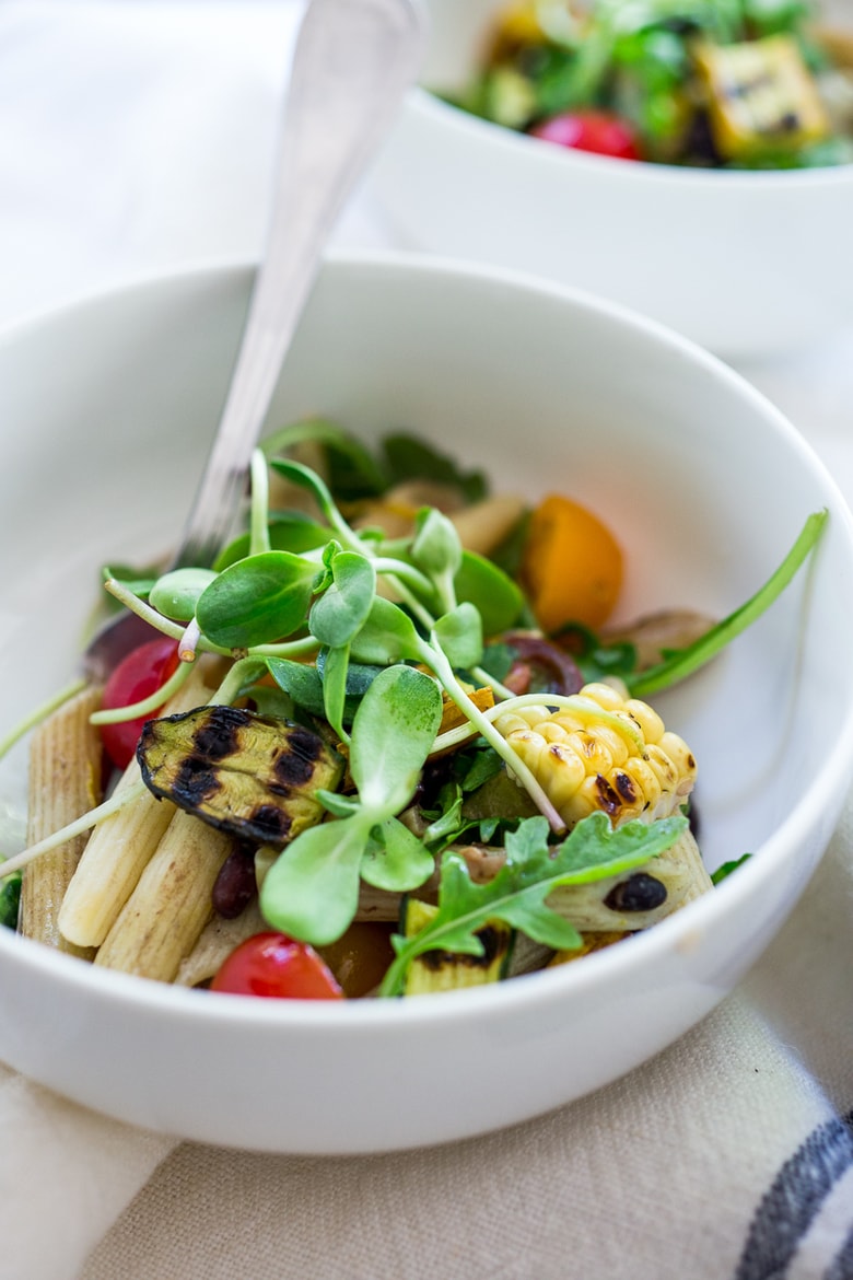 Farmers Market Pasta Salad with corn, cherry tomatoes and black beans. Make this summer pasta salad recipe gluten-free with optional grain-free pasta and keep it vegan or add feta. Very adaptable! Serve it warm for dinner or chilled for midweek lunches. | #zucchini #zucchinipasta #cornpasta #farmersmarket #summerpasta #pastasalad #glutenfree #vegan www.feastingathome.com #farmersmarketpasta