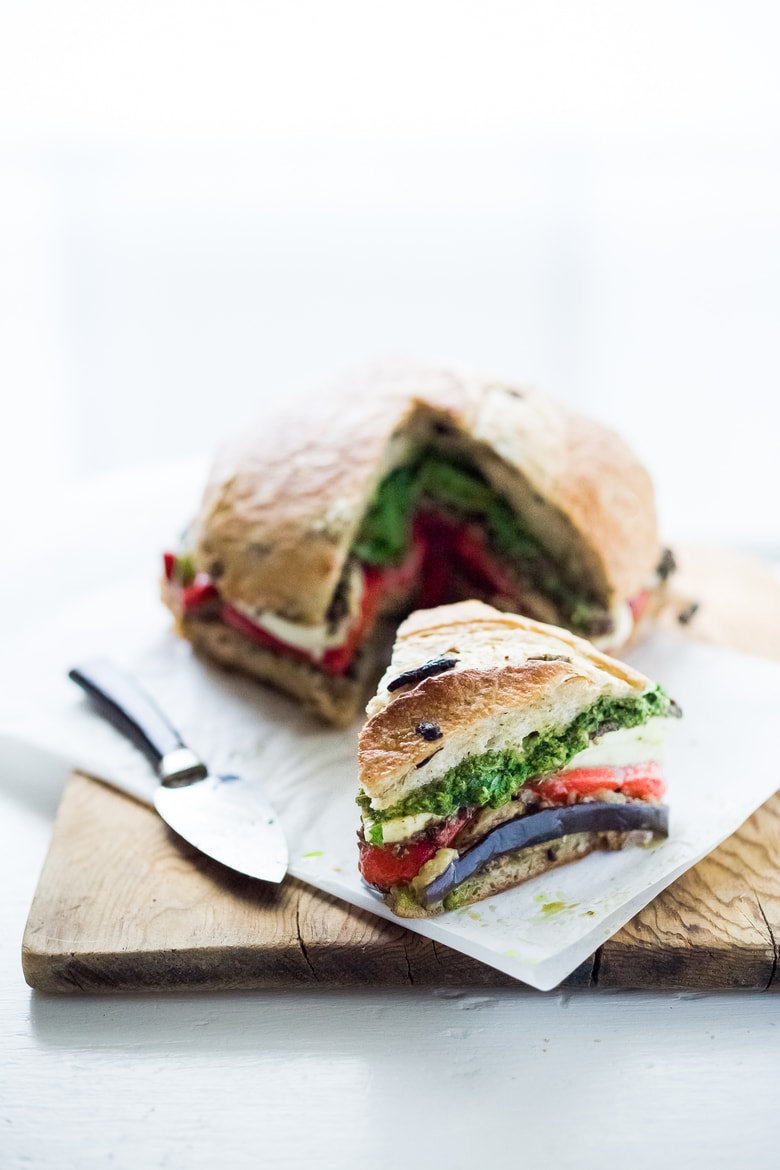 Grilled Eggplant Muffuletta Sandwich with Pesto, roasted peppers, olive tapenade and fresh mozzarella. All the flavors of summer in one bite! | www.feastingathome.com