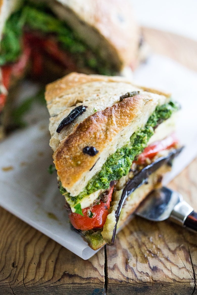 Grilled Eggplant Muffuletta Sandwich with Pesto, roasted peppers, olive tapenade and fresh mozzarella. All the flavors of summer in one bite! | www.feastingathome.com