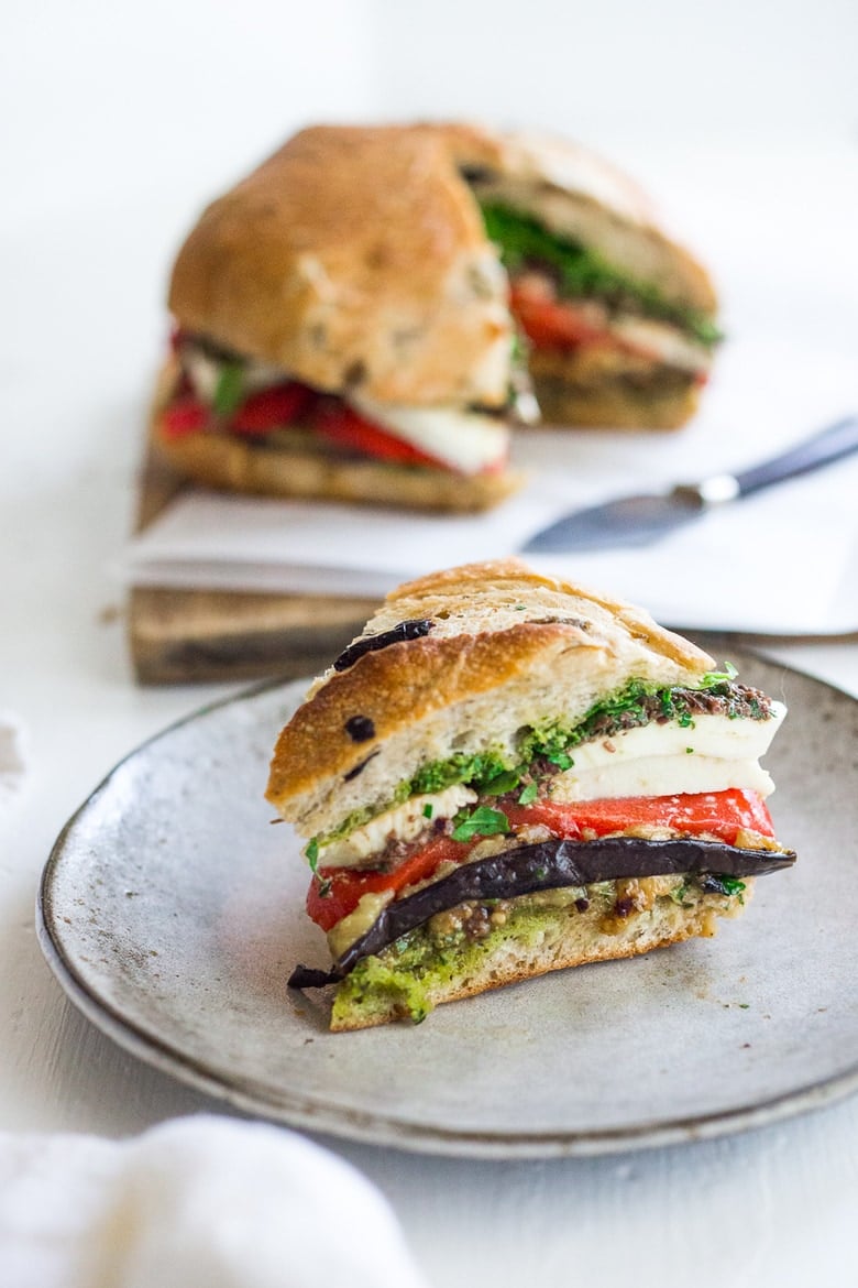 Grilled Eggplant Muffuletta Sandwich with Pesto, roasted peppers, olive tapenade and fresh mozzarella. All the flavors of summer in one bite! | www.feastingathome.com