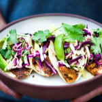 These Fish Tacos with cilantro lime taco slaw & creamy fish taco sauce can be made in under 30 minutes! Easy, healthy and full of amazing flavor!