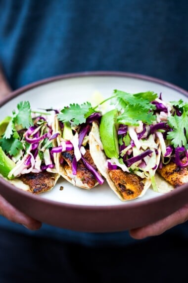 These Fish Tacos with cilantro lime taco slaw & creamy fish taco sauce can be made in under 30 minutes! Easy, healthy and full of amazing flavor!