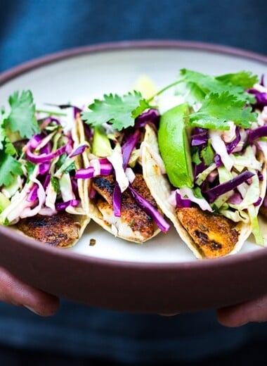 Fish Tacos with the best fish Taco Slaw. Cook on the grill, stove top or oven! Vegan & gluten-free adaptable- sub tofu for the fish! A fast, easy and healthy dinner that comes together in under 30 minutes.