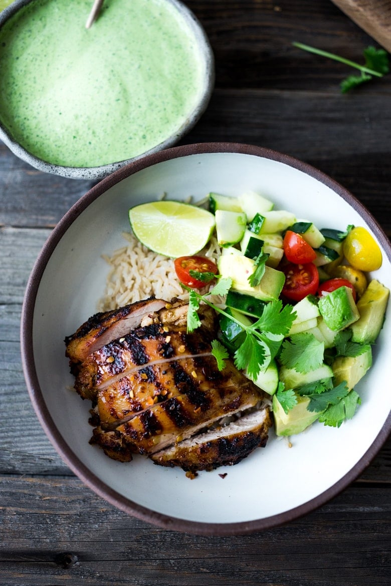 Peruvian Chicken (Pollo a la Brasa) with Aji Verde Sauce, rice and avocado salad in a bowl. 