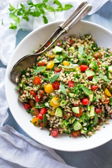 A simple delicious recipe for Farro Tabbouleh Salad loaded up with summer veggies, herbs and simple lemon dressing. Vegan! | www.feastingathome.com