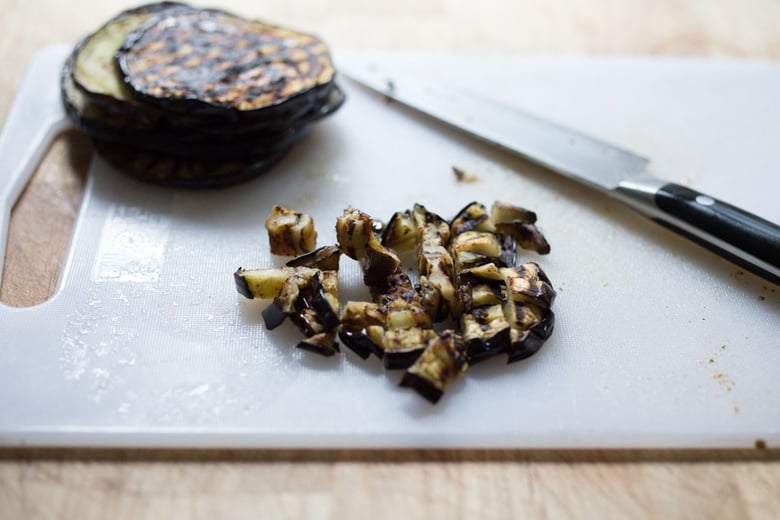 This Sicilian recipe for Eggplant Caponata- is simple, easy and full of summer flavor! Serve it as a healthy vegan appetizer over crostini, or as a delicious side dish, or turn it into an eggplant "salad" served over greens and grains! Low- Carb  and Vegan! #eggplantrecipes #eggplantcaponata #caponata #feastingathome #grilledeggplant #vegan #healthy 