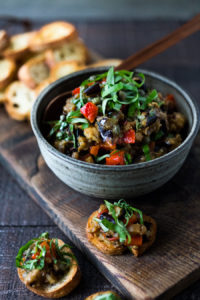 This Sicilian recipe for Eggplant Caponata- is simple, easy and full of summer flavor! Serve it as a healthy vegan appetizer over crostini, or as a delicious side dish, or turn it into an eggplant "salad" served over greens and grains! Low- Carb  and Vegan! #eggplantrecipes #eggplantcaponata #caponata #feastingathome #grilledeggplant #vegan #healthy