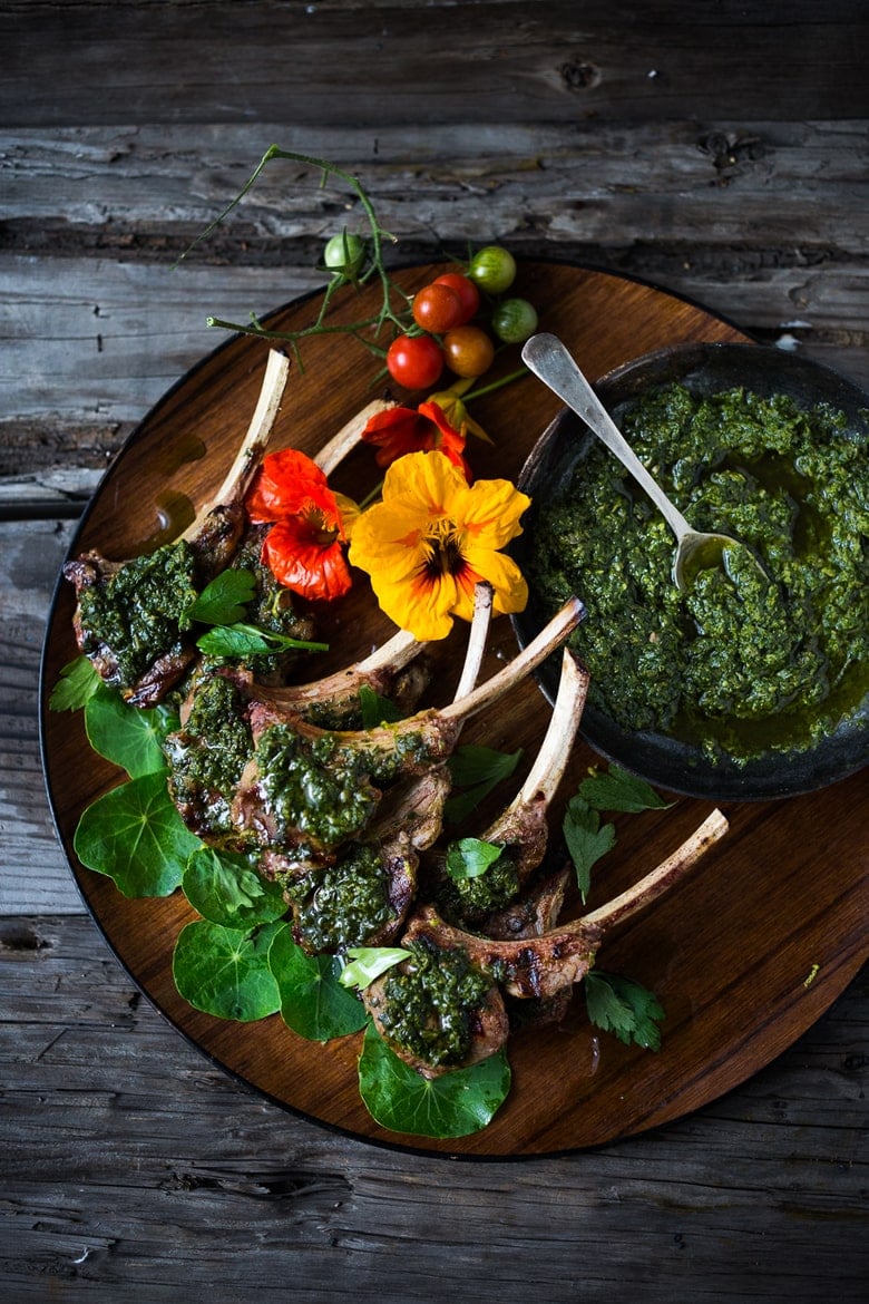 Grilled LAMB LOLLY POPS - grilled single lamb chops topped with the most flavorful Italian Herb Caper Sauce, called Salsa Verde. Serve as a a quick, easy appetizer. Fast, flavorful and so delicious! | www.feastingathome.com