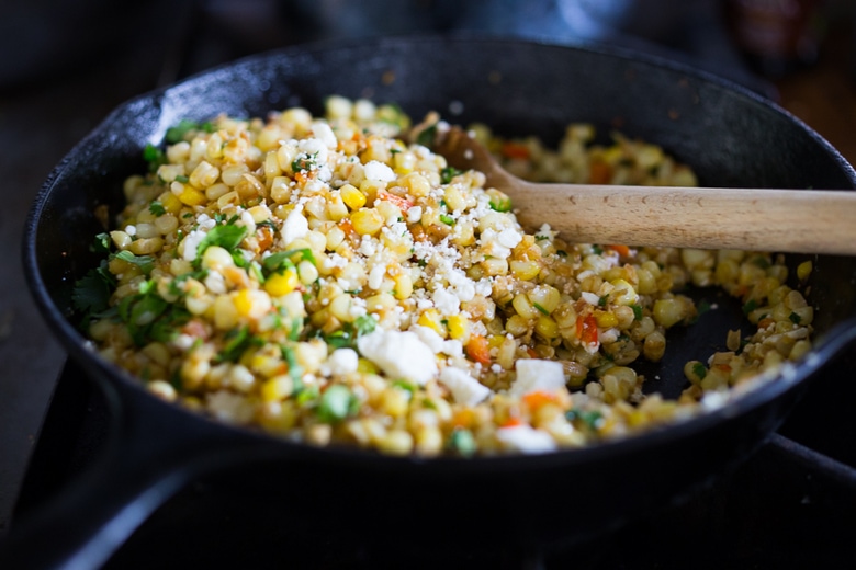 Mexican Street Corn with chilies, cilantro and lime - also called Elotes. This lighter version can be grilled or sautéed and can easily be made vegan! | www.feastingathome.com 