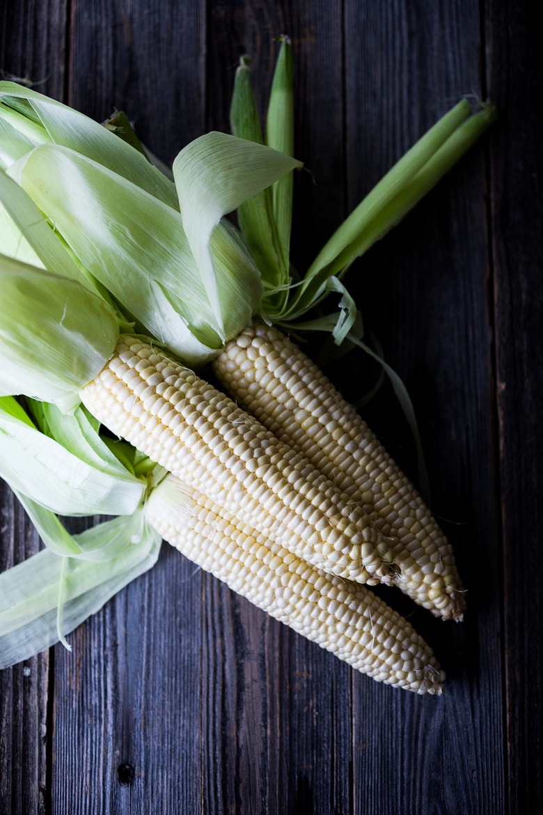 Mexican Street Corn with chilies, cilantro and lime - also called Elotes. This lighter version can be grilled or sautéed and can easily be made vegan! | www.feastingathome.com