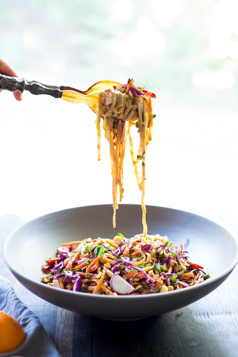 A fork full of Thai Noodle Salad with Peanut Sauce in a bowl.