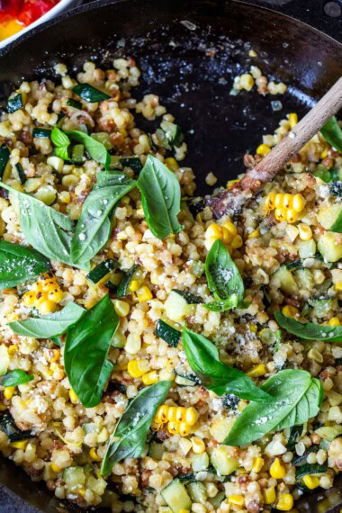 In this recipe for Fregola pasta, summer corn, and zucchini are paired with basil, pecorino, and lemon zest- a cozy, end-of-summer meal.