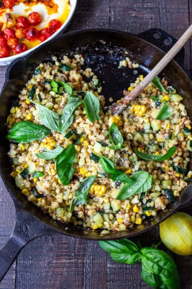 A simple recipe for Fregola Sarda with corn, zucchini, and basil sprinkled with pecorino. A simple and easy Italian-inspired meal that comes together in 30 minutes.
