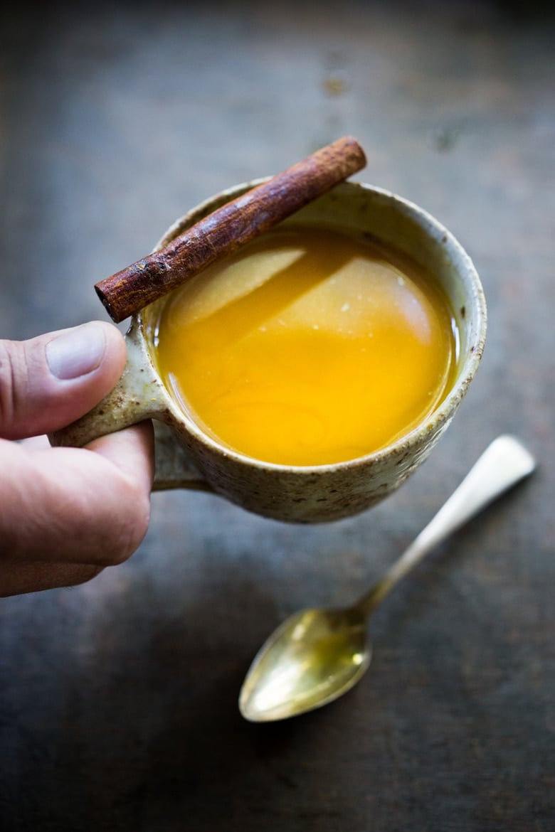 Jamu Juice- Bali's all-natural, anti-inflammatory elixir- made with fresh turmeric, ginger, honey and a squeeze of lemon. Heals and soothes the body! Make a big batch and serve hot or cold during the busy workweek! #turmeric #turmerictea | www.feastingathome.com