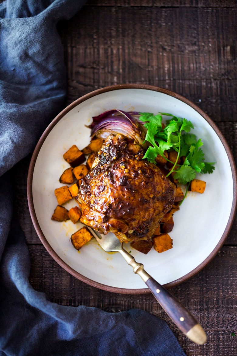 Sheet-Pan Harissa Chicken and roasted Sweet Potatoes- just 15 minutes of hands on time, before baking in the oven. Smoky, earthy, fragrant, North African Spices ! #harissa #harissachicken #chicken # sheetpandinner | www.feastingathome.com