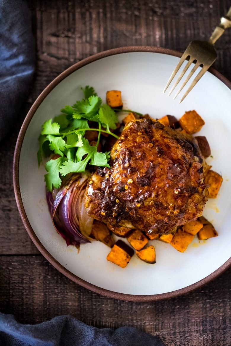 Sheet-Pan Harissa Chicken and roasted Sweet Potatoes- just 15 minutes of hands on time, before baking in the oven. Smoky, earthy, fragrant, North African Spices ! #harissa #harissachicken #chicken # sheetpandinner | www.feastingathome.com