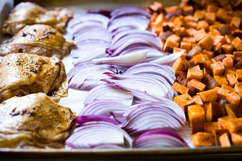 Sheet-Pan Harissa Chicken and roasted Sweet Potatoes- just 15 minutes of hands on time, before baking in the oven. Smoky, earthy, fragrant, North African Spices ! #harissa #harissachicken #chicken # sheetpandinner | www.feastingathome.com