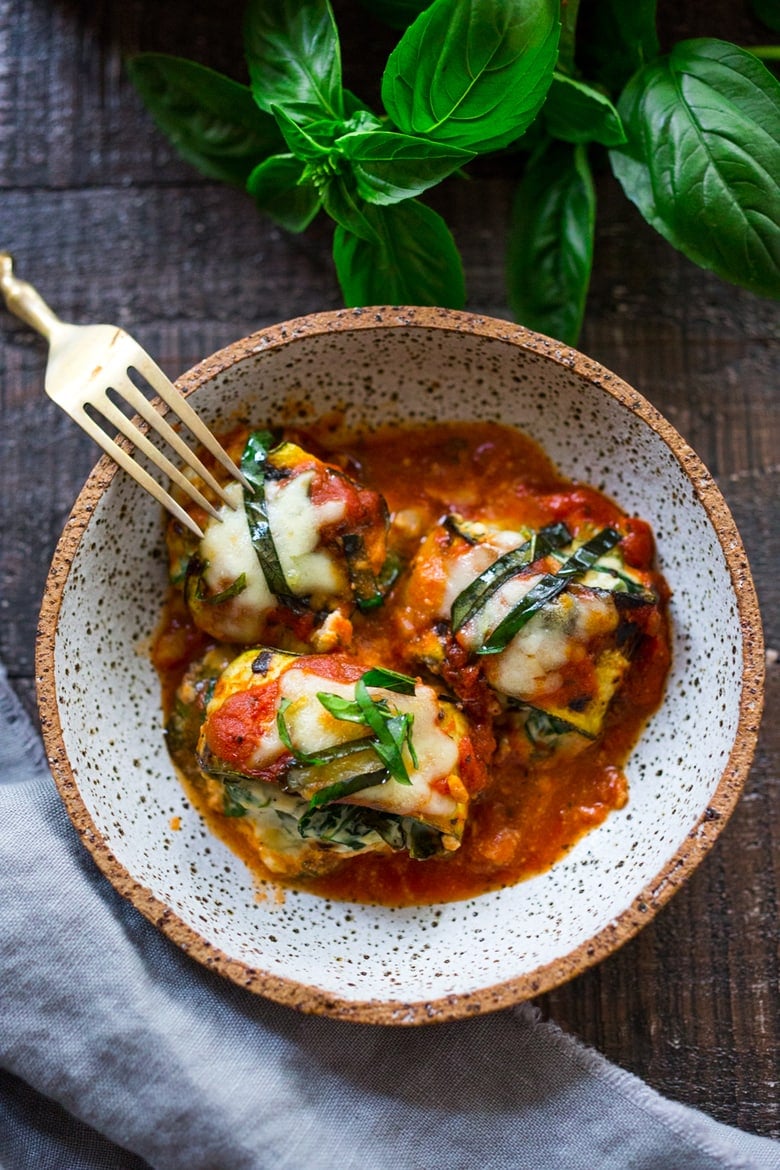 Zucchini Rolls with Spinach and Basil, baked in marinara sauce and topped with optional smoked mozzarella.| www.feastingathome.com 