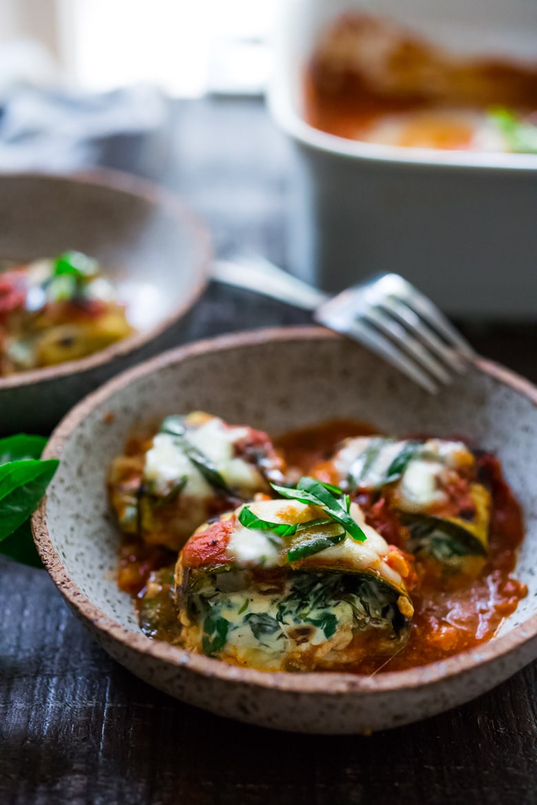 Zucchini Rolls with Spinach and Basil, baked in marinara sauce and topped with optional smoked mozzarella.| www.feastingathome.com 