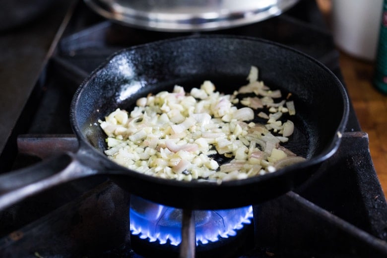 cast iron skillet with sautéed shallot and garlic.