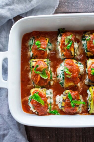 These zucchini roll-ups with spinach, ricotta, and basil are vegetarian and baked in flavorful tomato sauce. Low-carb, gluten-free, vegan-adaptable. Video