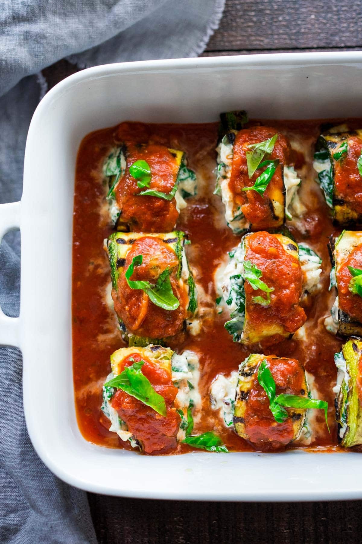 These zucchini roll-ups with spinach, ricotta, and basil are vegetarian and baked in flavorful tomato sauce. Low-carb, gluten-free, vegan-adaptable. Video