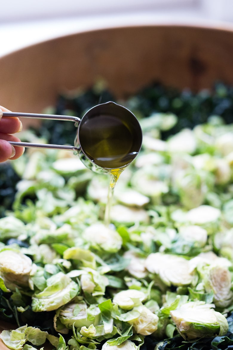 A hearty, healthy Roasted Fall Vegetable Salad with Maple Curry Vinaigrette on a bed of shredded kale and brussel sprouts. Vegan and GF. | www.feastingathome.com