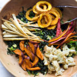 A hearty, healthy Roasted Fall Vegetable Salad with Maple Curry Vinaigrette on a bed of shredded kale and brussel sprouts. Vegan and GF.