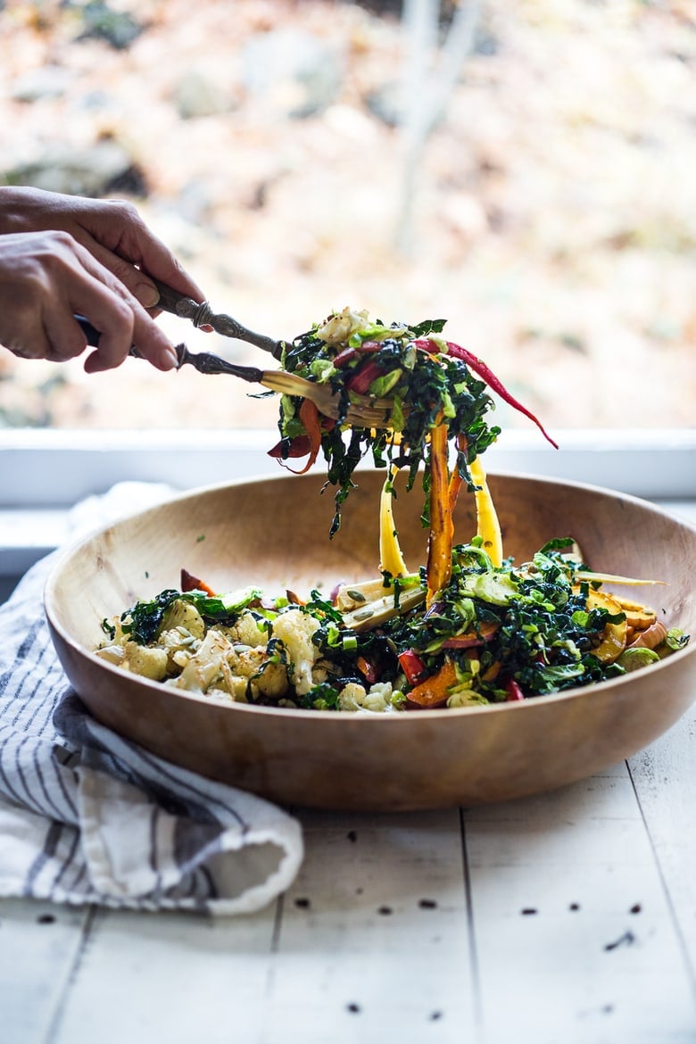 A hearty, healthy Roasted Fall Vegetable Salad with Maple Curry Vinaigrette on a bed of shredded kale and brussel sprouts. Vegan and GF. | www.feastingathome.com