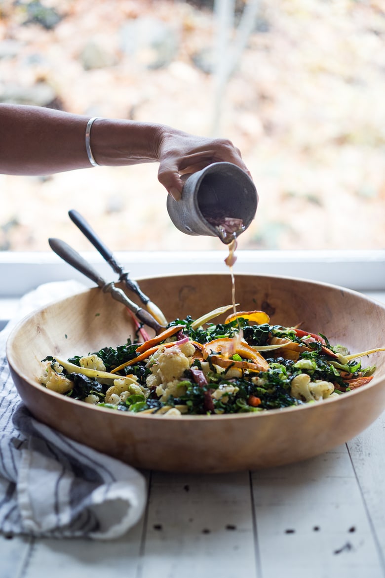 A hearty, healthy Roasted Fall Vegetable Salad with Maple Curry Vinaigrette on a bed of shredded kale and brussel sprouts. Vegan and GF. | www.feastingathome.com