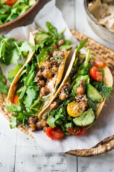 EAT CLEAN with these 20 simple Plant-Based Meals || Middle Eastern Salad Tacos with spiced chickpeas, hummus and a mound of lemony salad, topped with fresh herbs and scallions. Vegan & sooooo Delicious! | #plantbased #cleaneating #saladtacos #detox #veganrecipes #eatclean #healthy #healthyrecipes #healthylunchideas #tacos #vegantacos |www.feastingathome.com