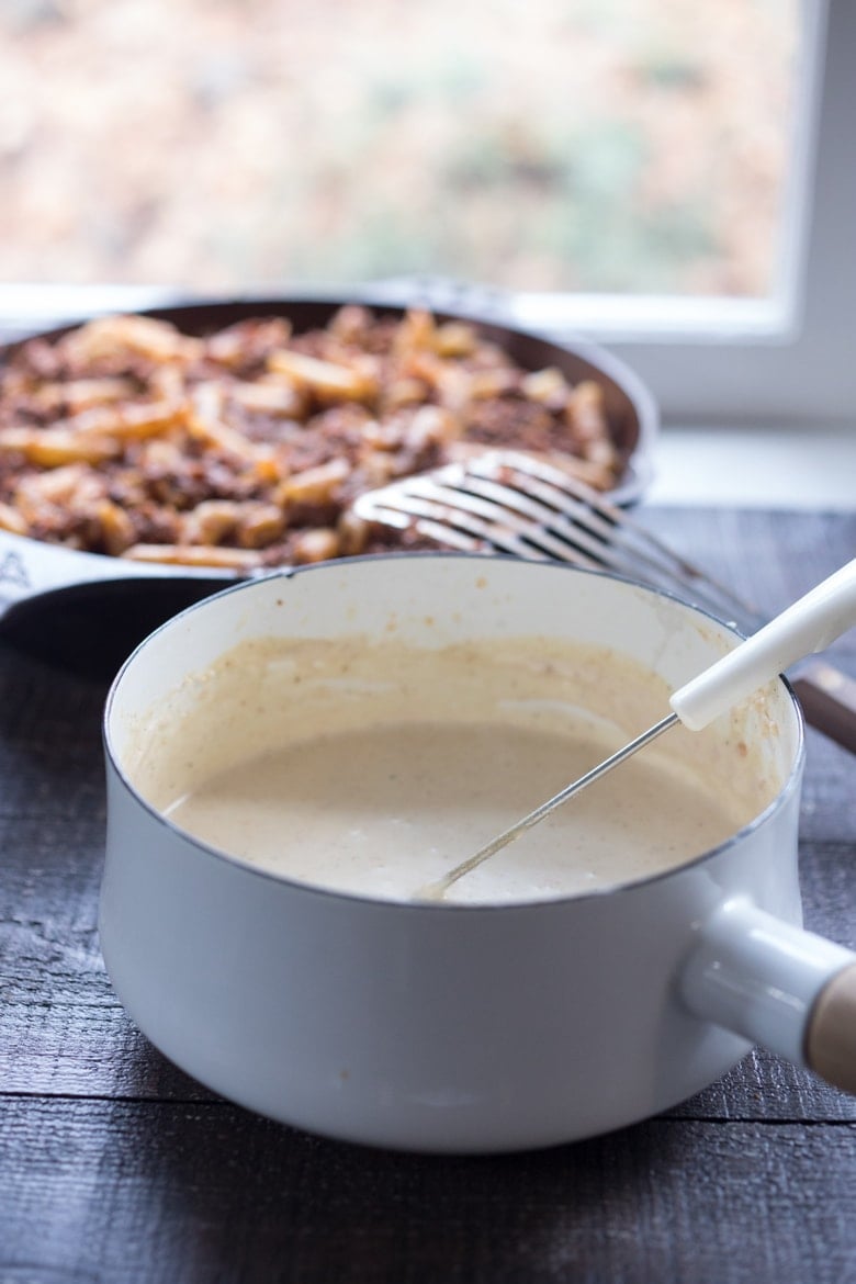 béchamel sauce whisked together in pot.