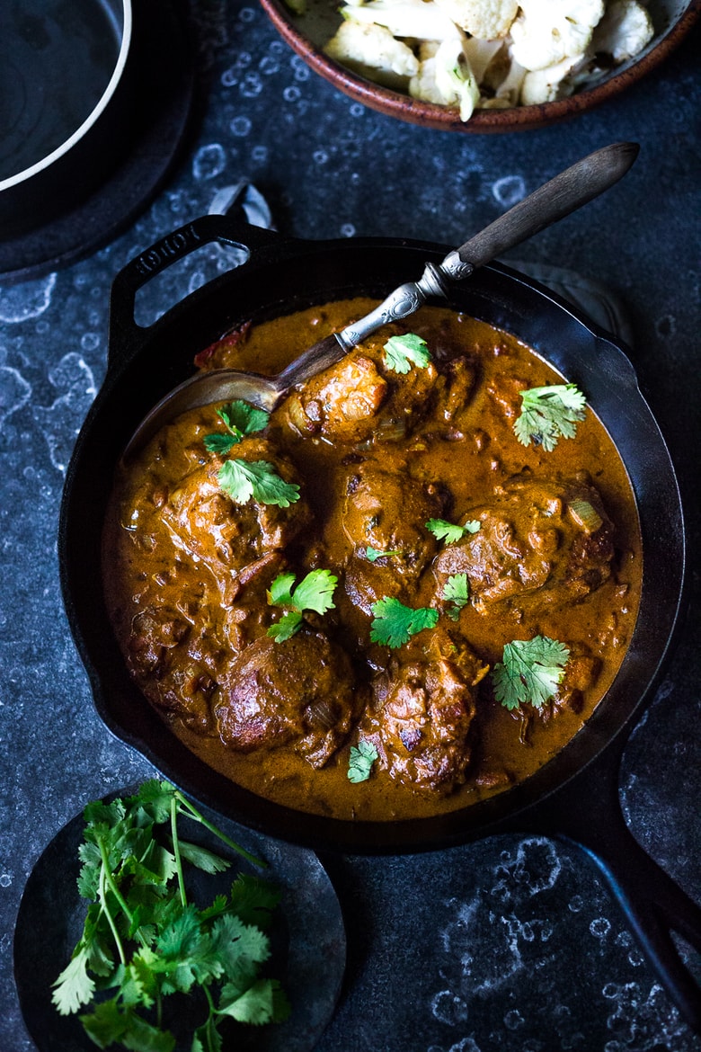 Indian Butter Chicken (or Cauliflower) in the most flavorful Tomato Ginger Coconut Curry Sauce! Serve over roasted cauliflower or brown basmati rice- a flavorful meal that is vegan adaptable! | www.feastingathome.com