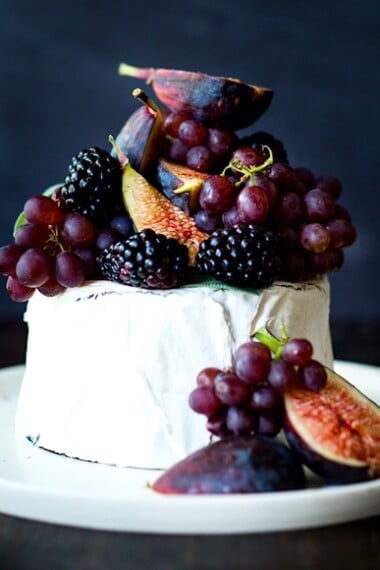 Simple, beautiful Brie Cake topped with fresh berries, figs and grapes, drizzled with honey and served with seeded crackers -  an easy, festive appetizer or dessert, perfect for celebrations and gatherings.  | www.feastingathome.com