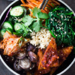Korean-Style Seoul Bowl ( Bibimbap!) with Gochujang baked Tempeh, steamed veggies, kimchi and pickled cucumber- a healthy vegan version of Bibimbap!