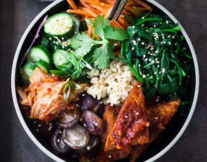 Korean-Style Seoul Bowl ( Bibimbap!) with Gochujang baked Tempeh, steamed veggies, kimchi and pickled cucumber- a healthy vegan version of Bibimbap!