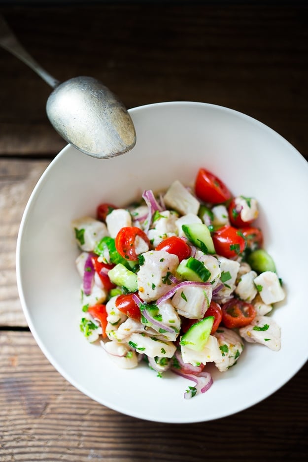 How to make the Best Ceviche! Ceviche is typically made with fresh fish (or shrimp) cured with lime juice, then tossed with onions, cilantro, tomato and cucumber.  Serve it as an appetizer with tortilla chips or as a light, refreshing summer meal. #ceviche