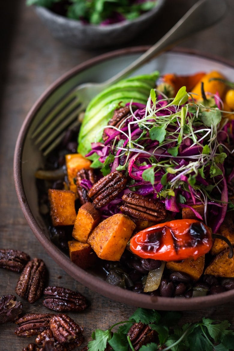  Vegan Mexican-style, Oaxacan Bowl with roasted chipotle sweet potatoes and sweet peppers over a bed of warm seasoned black beans. Topped with a crunchy cabbage slaw, avocado and toasted Chipotle Maple Pecans. | www.feastingathome.com