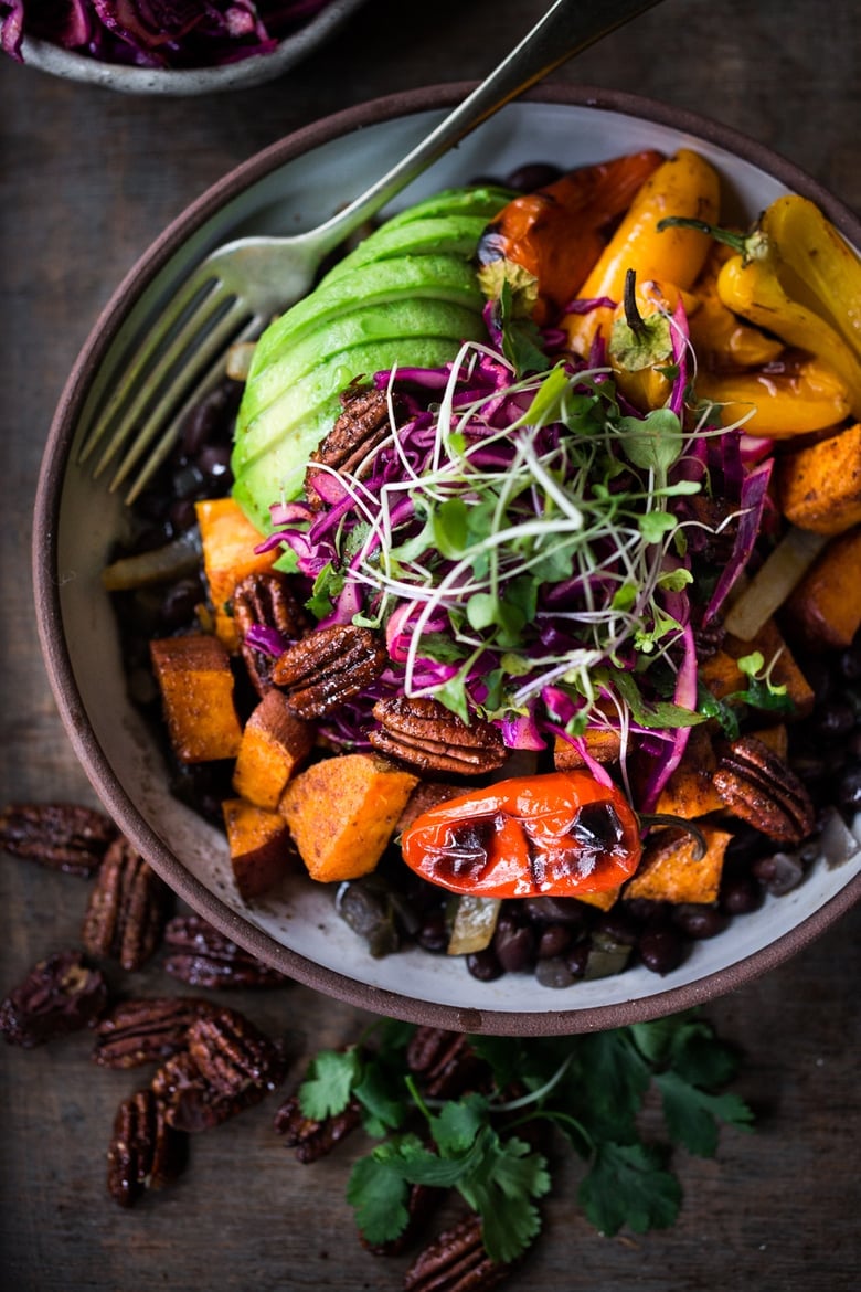  Vegan Mexican-style, Oaxacan Bowl with roasted chipotle sweet potatoes and sweet peppers over a bed of warm seasoned black beans. Topped with a crunchy cabbage slaw, avocado and toasted Chipotle Maple Pecans. | www.feastingathome.com