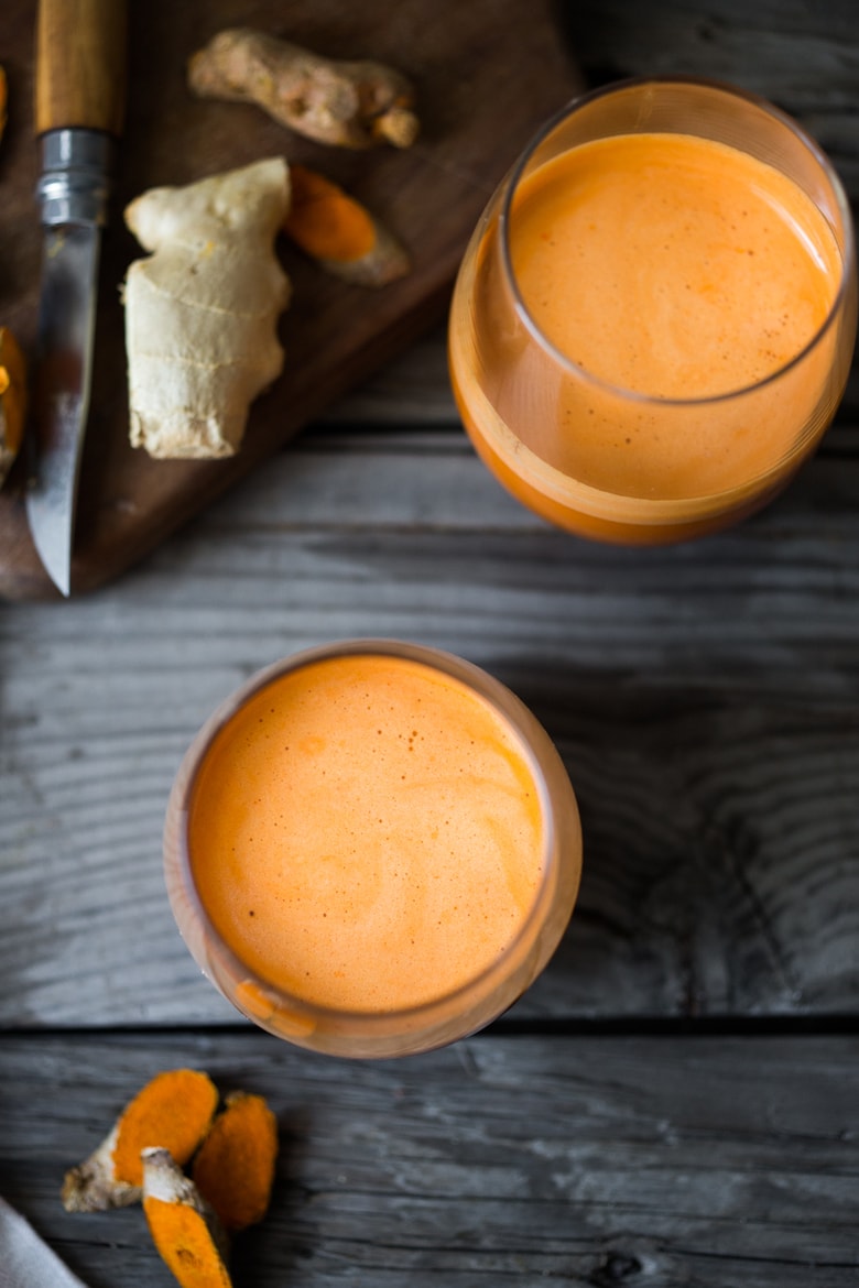 Carrot turmeric ginger juice with apple, in a glass. 