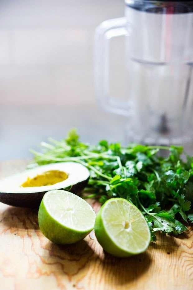 avocado sauce ingredients, next to a blender. 