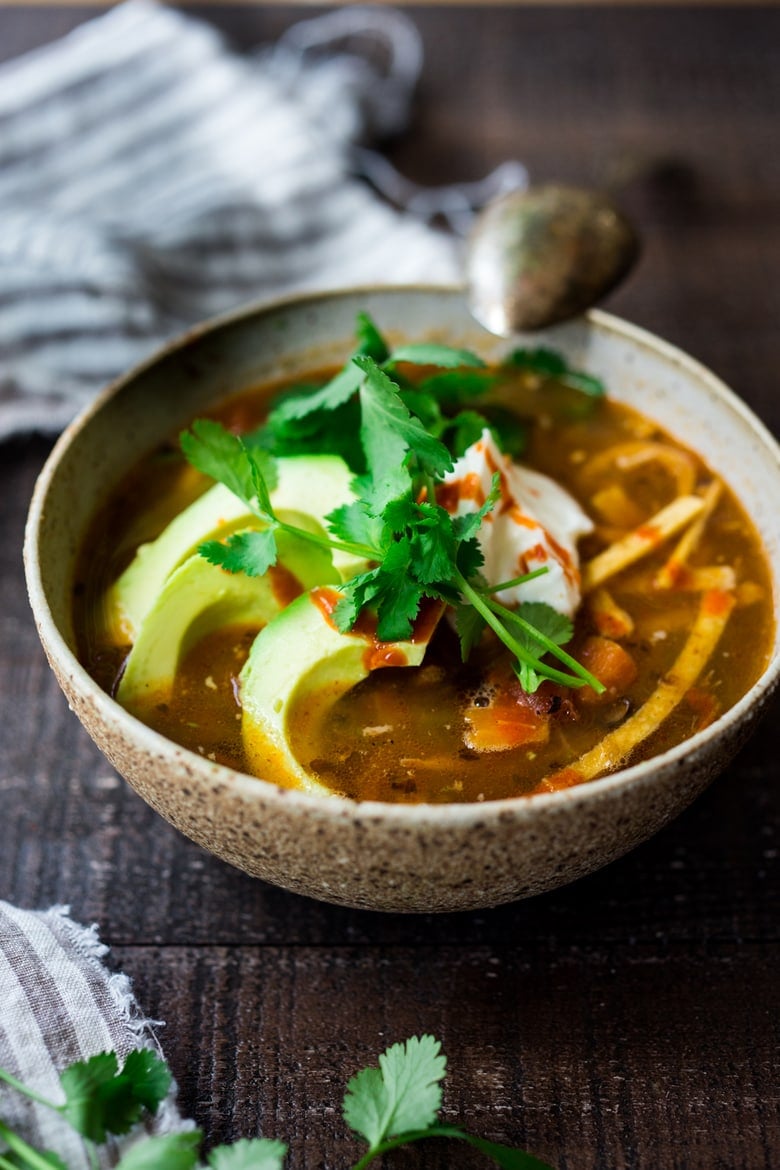 This Chicken Tortilla Soup is one of BEST recipes on the blog and hands-down one of our favorite dinners. Delicious and healthy, loaded with chicken and veggies, this soup will warm you to your bones! Make it in an Instant pot, on the stovetop, or in a slow cooker!