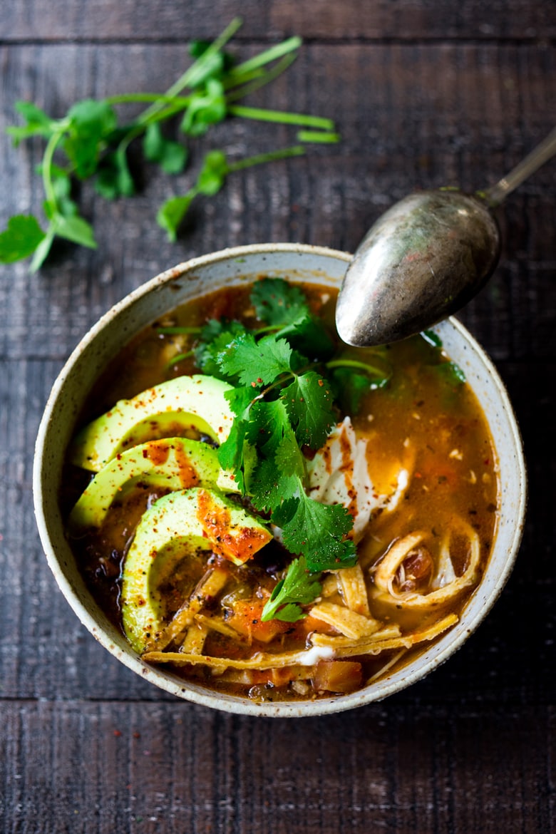 Instant Pot Chicken Tortilla Soup - made from scratch and in a fraction of the time! Delicious and hearty, loaded with chicken and healthy veggies, this chicken soup recipe will warm you to your bones! #instantpot #instantpotsoup #tortillasoup #instantpotreicpes #instantpotchickensoup #chickentortillasoup #feastingathome