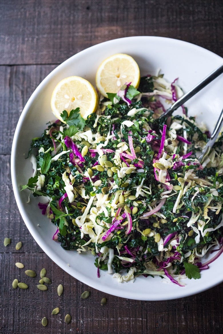 This simple Kale Slaw with Lemony Dressing can be made ahead, then used throughout the week to top off tacos, wraps, buddha bowls, burgers, and even pizza. An easy way to get in your dark leafy greens.  Vegan and Gluten-Free, this amazing kale slaw keeps up to 4 days in the fridge.