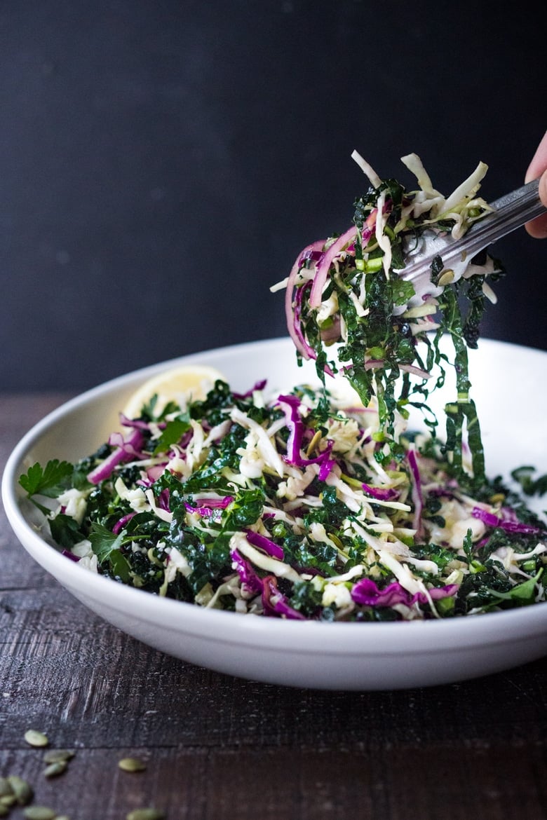 This simple Kale Slaw with Lemony Dressing can be made ahead, then used throughout the week to top off tacos, wraps, buddha bowls, burgers, and even pizza. An easy way to get in your dark leafy greens.  Vegan and Gluten-Free, this amazing kale slaw keeps up to 4 days in the fridge.