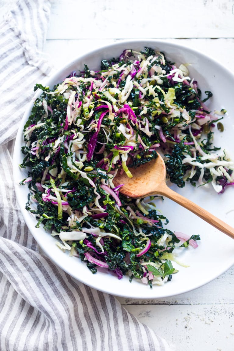 This simple Kale Slaw with Lemony Dressing can be made ahead, then used throughout the week to top off tacos, wraps, buddha bowls, burgers, and even pizza. An easy way to get in your dark leafy greens.  Vegan and Gluten-Free, this amazing kale slaw keeps up to 4 days in the fridge.