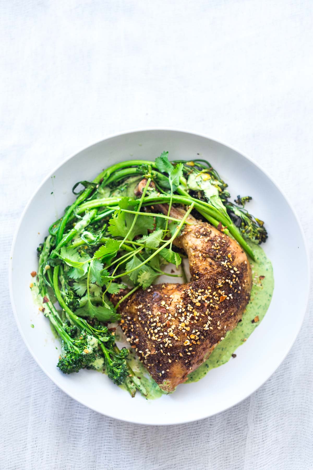This Za'atar Chicken recipe pairs juicy, crispy chicken thighs with roasted broccolini and a vibrant green tahini sauce for an easy, flavor-packed Middle Eastern-inspired dinner.