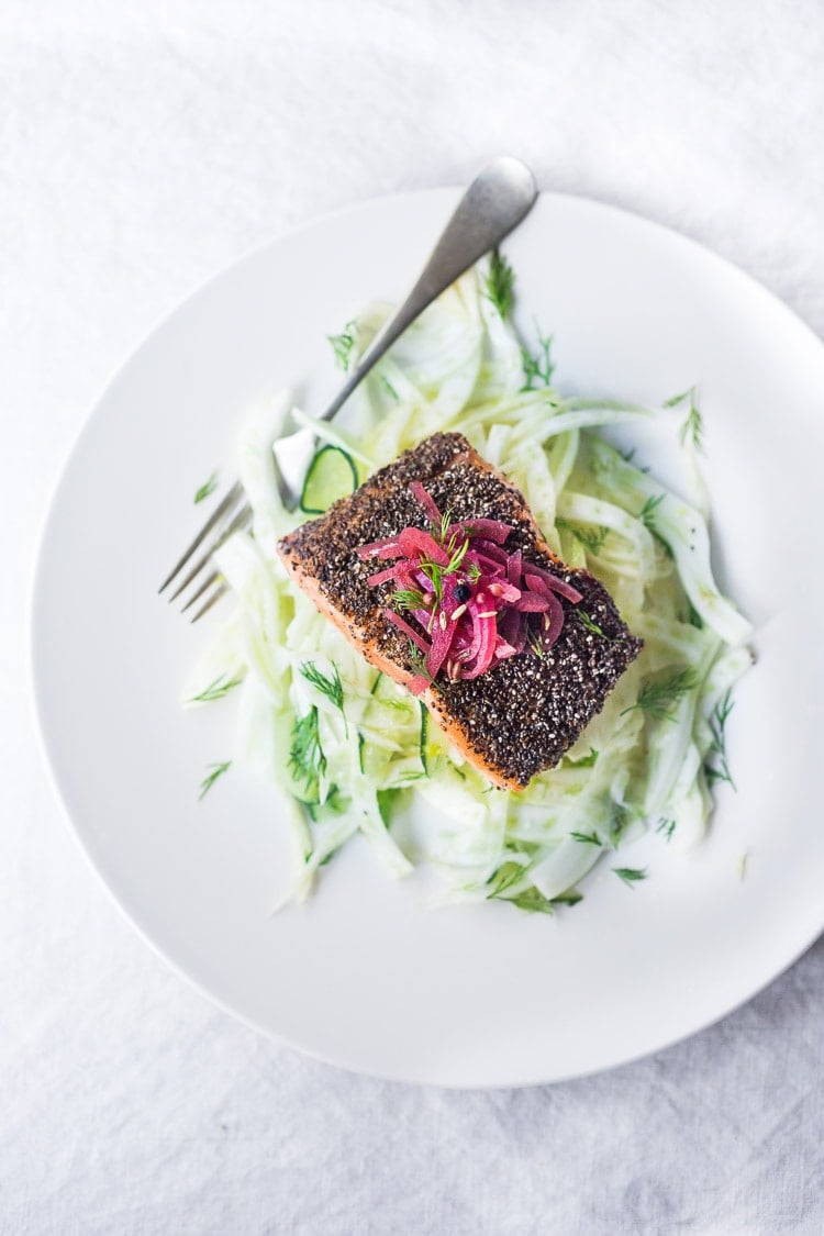 Pan Seared Salmon with chia seeds, served hot and crispy over cool crunchy fennel slaw, topped with quick pickled onions and fresh dill. A simple, healthy, pan-seared salmon recipe that is paleo and low carb! #salmon #fennel #chia #fennelslaw #fennelsalad #paleo #lowcarb #glutenfree 