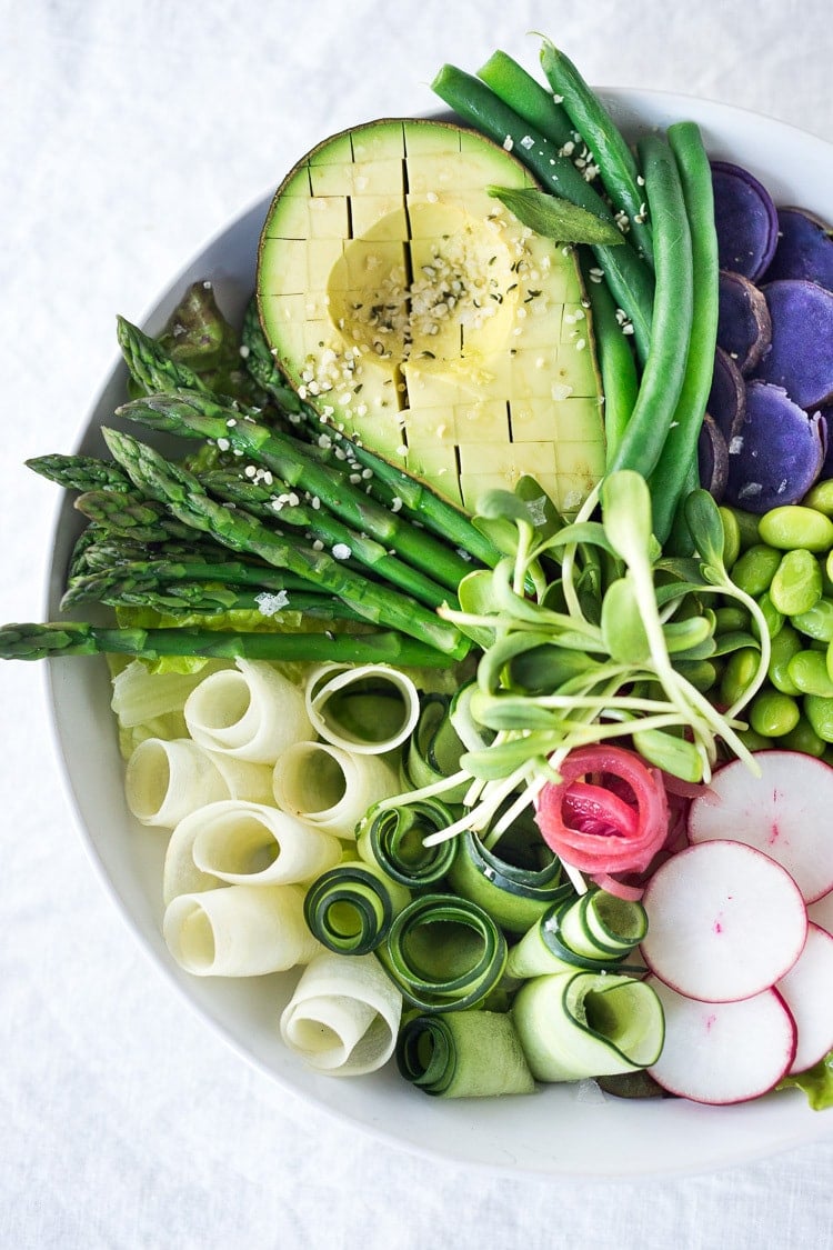 Green Goddess Bowl featuring the best of fresh spring produce arranged beautifully over a bed of greens or grains, and topped with a creamy vegan green goddess dressing. 