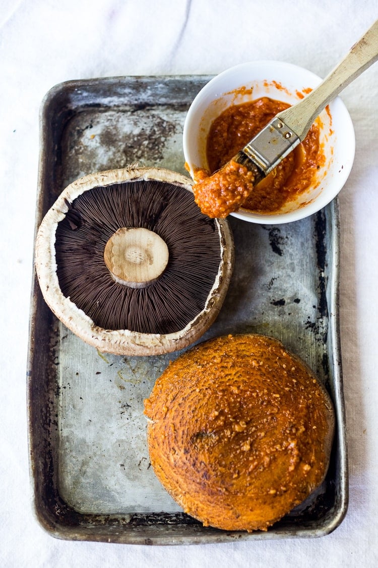 This Asian-style, grilled, vegan portobello mushroom burger is full of delicious umami flavor! It's lathered with Asian-style Guacamole, topped with a cool cucumber ribbon salad and crunchy carrot slaw. Healthy, delicious and really satisfying. AND totally vegan! #veganburger #portobelloburger #veganportobelloburger #portobellomushroomrecipes #portobello #vegan #veganburger #grilled #grilledportobello 